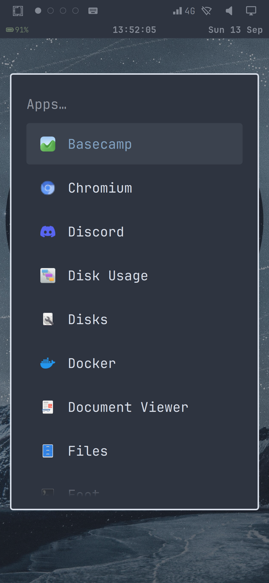 The Omarchy apps menu open on the phone showing a scrollable list of applications
